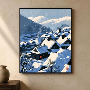 May include: A framed art print depicting a snowy village scene with dark wooden houses, deep blue shadows, and white snow-covered roofs. A single red lantern glows near a house, while smoke rises into a pale blue sky against distant mountains.