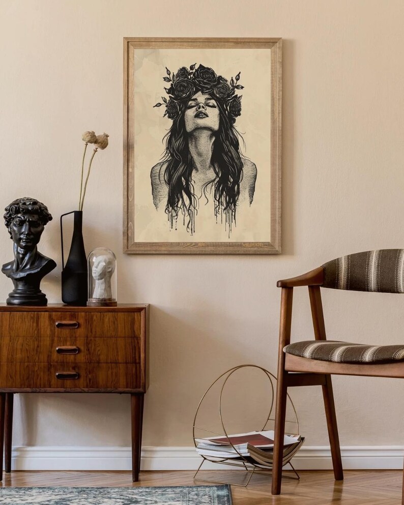 May include: A framed wall art print featuring a black ink illustration of a person with long hair and a crown of roses. The person has their head tilted back with eyes closed. The artwork is set against a light beige, textured background.