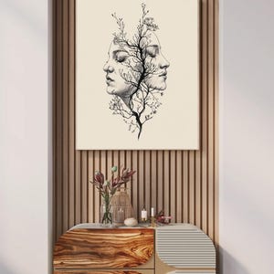 以下が含まれることがあります： 黒いインクの線画で描かれた、互いに背を向けた二つの横顔と、その間に成長する中央の樹木構造が特徴の額入りウォールアートプリント。背景は無地のクリーム色で、全体的にシンプルなデザインとなっている。