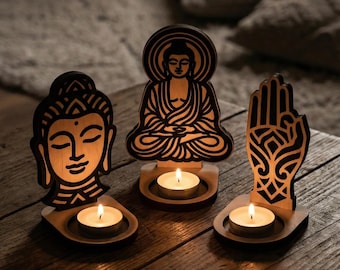 Peut inclure: Trois bougeoirs en bois avec des motifs de Bouddha et de main. Chaque bougeoir contient une petite bougie allumée. Les figures de Bouddha sont dans différentes poses. Les bougeoirs sont sur une surface en bois.