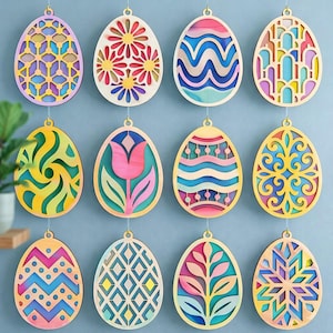May include: A collection of twelve wooden Easter egg ornaments. Each egg features a unique layered design with various colors, including yellow, pink, blue, and green. The eggs are suspended by thin strings, ready for display as Easter decorations.
