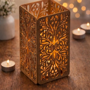 Puede incluir: Un portavelas de madera cortado con láser con un diseño intrincado y ornamentado. El soporte rectangular está hecho de madera marrón claro y presenta un patrón floral. El texto "Laser Cut Wooden Candle Holder - Intricate Ornate Design" y "DIGITAL FILE" son visibles.