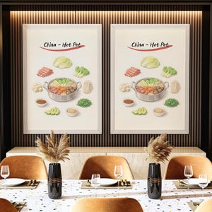 Puede incluir: Dos impresiones enmarcadas de una ilustración de olla caliente cuelgan sobre una mesa de comedor. Las impresiones presentan una olla de comida rodeada de ingredientes y el texto "China - Hot Pot". La mesa está puesta con platos, vasos y sillas.
