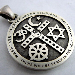 May include: A silver pendant with a circular design featuring symbols of different religions, including a cross, a Star of David, a crescent moon, a yin-yang symbol, and a Dharmachakra. The pendant has the text "When there is peace among religions there will be peace in the world - Dalai Lama".