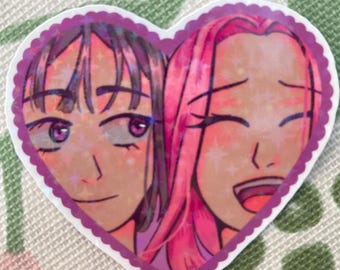 May include: A heart-shaped sticker featuring two anime-style characters. One has dark hair and a neutral expression, the other has pink hair and is smiling. The sticker has a purple scalloped border and a holographic finish.