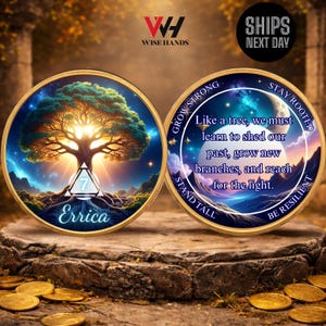 May include: Two gold-colored coins with a tree design and the text "Errica". One coin has a tree illustration, the other has a quote about growth. The coins are on a stone surface.