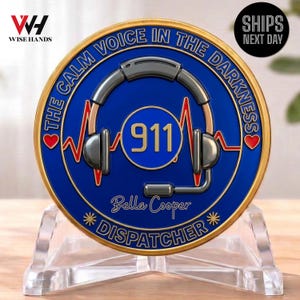 Peut inclure: Une pièce de monnaie ronde, bleue et dorée, avec le texte "THE CALM VOICE IN THE DARKNESS" et "911". La pièce présente un graphique de casque et le nom "Bella Cooper DISPATCHER". Elle est présentée sur un présentoir en acrylique transparent.