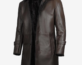 May include: A brown leather coat with a black faux fur collar and lining. The coat has a button-down front, long sleeves, and a knee-length design. The coat has a classic, tailored look.