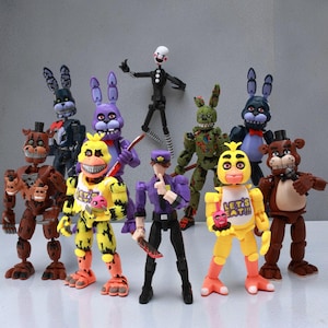 May include: A collection of articulated action figures featuring characters from the Five Nights at Freddy's franchise. The figures include various animatronic animals and human characters in a variety of colors.