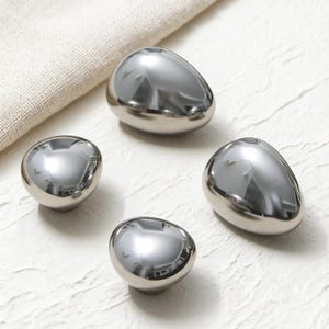 Puede incluir: Un juego de tres tazas de cerámica con un acabado mate moteado. Cada taza presenta un color diferente: azul claro, crema y gris. Las tazas tienen un diseño simple y moderno con una forma redondeada y un asa cómoda.