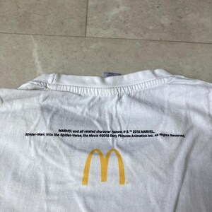 K&ouml;nnte beinhalten: Ein wei&szlig;es T-Shirt mit einem gelben McDonald's-Logo in Form goldener B&ouml;gen, gedruckt unter einem schwarzen Text, der lautet: MARVEL and all related character names: &copy; & &trade; 2018 MARVEL. Spider-Man: Into the Spider-Verse, the Movie &copy;2018 Sony Pictures Animation Inc. All Rights Reserved.