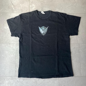 May include: Black short-sleeved t-shirt with a graphic design on the front. The design is a shield shape with wings and a soccer ball in the center. The shirt is made of a soft, worn material.