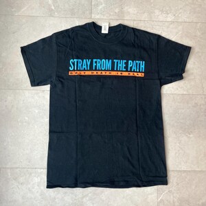 May include: Black t-shirt with the text "STRAY FROM THE PATH" in blue and "ONLY DEATH IS REAL" in orange. The shirt is laid flat on a light-colored surface.