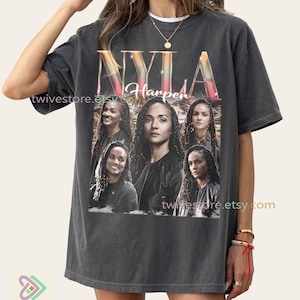 May include: Dark gray t-shirt featuring the name "NYLA Harper" in a colorful, gradient font. The shirt displays multiple images of a woman. The Etsy shop URL "twivestore.etsy.com" is visible on the shirt.