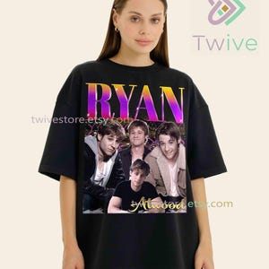 May include: Black oversized t-shirt featuring a graphic of four men with the name "RYAN" in a gradient font. The text "Atwood" is below the image. The Etsy shop name "twivestore.etsy.com" is also visible.