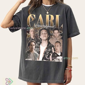 Op de afbeelding: Donkergrijs t-shirt met gouden "CARL"-opschrift en "Gallagher" eronder. Het shirt toont een collage van afbeeldingen van een persoon. De Etsy shopnaam "twivestore.etsy.com" is op het shirt gedrukt.