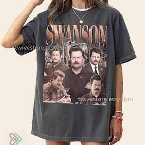 May include: Dark grey t-shirt with a copper-coloured graphic of a man with a moustache in different poses, and the text "Swanson Rose". The shirt has a vintage appearance.