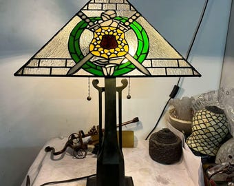 手作りステンドグラスの鳥型テーブルランプ｜緑のリングに囲まれた温かみのある光が、散らかったデスクに穏やかなひとときを演出します