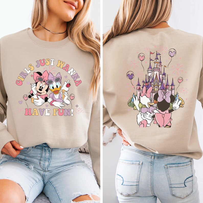 May include: Beige sweatshirt with Minnie Mouse and Daisy Duck on the front, and the text "GIRLS JUST WANNA HAVE FUN!". The back features the characters with a castle and balloons.