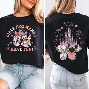 May include: Black sweatshirt with a graphic of Minnie Mouse and Daisy Duck, and the text "GIRLS JUST WANNA HAVE FUN!" on the front. The back shows a castle, fireworks, and Minnie and Daisy.