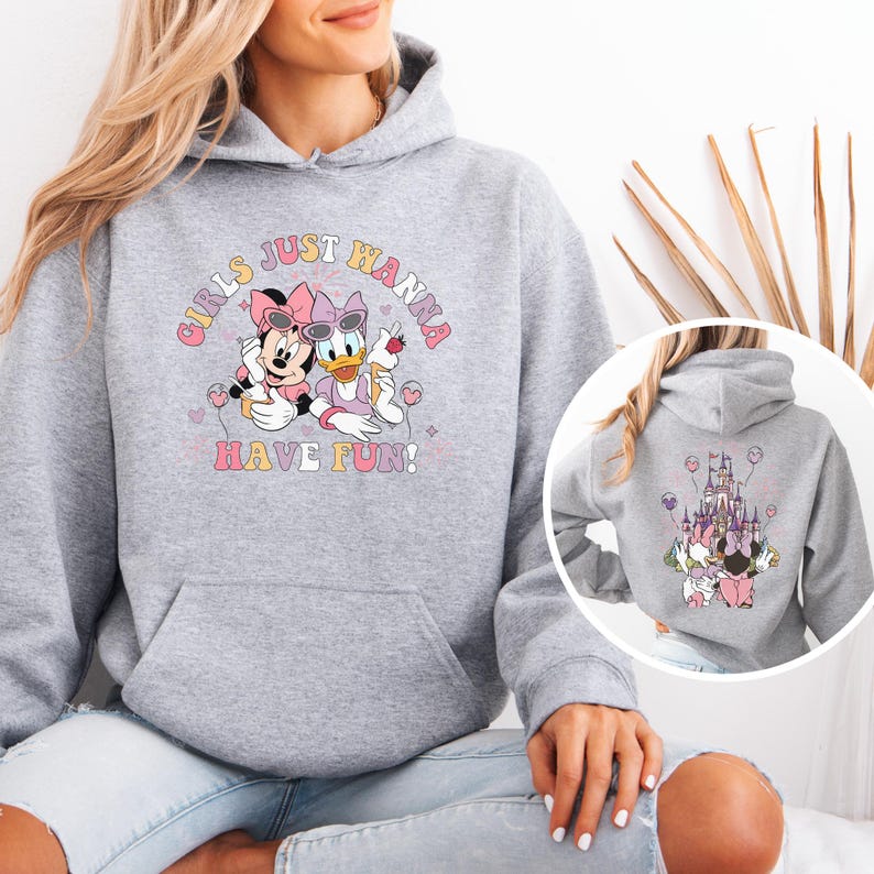 May include: A light grey hooded sweatshirt with a graphic of Minnie Mouse and Daisy Duck, and the text "GIRLS JUST WANNA HAVE FUN!". The back of the sweatshirt has a graphic of a castle and the same characters.