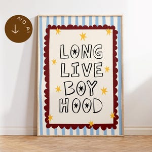 Può includere: Una stampa artistica incorniciata con il testo LONG LIVE BOYHOOD in lettere maiuscole nere. Il design include stelle gialle, un bordo smerlato rosso scuro e uno sfondo a righe verticali azzurre e bianche all'interno di una cornice in legno.