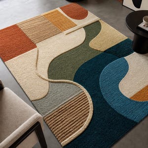 Könnte beinhalten: Ein moderner Teppich mit abstraktem Design. Der Teppich hat eine Mischung aus Farben wie Rost, Beige, Grün und Blau. Das Design integriert geometrische Formen und geschwungene Linien und schafft einen modernen Look. Der Teppich besteht aus weichem, strukturiertem Material.