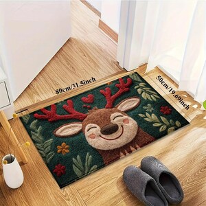 May include: A rectangular doormat featuring a smiling cartoon reindeer with red antlers and a green background with leaves and flowers. The mat measures 31.5 inches by 19.69 inches.