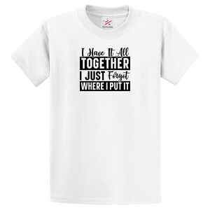 May include: A white t-shirt with the text "I Have It All TOGETHER I JUST Forgot WHERE I PUT IT" in black. The shirt has short sleeves and a crew neck. The brand logo is visible on the upper right side of the shirt.