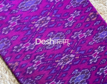 May include: A vibrant magenta fabric featuring a repeating ikat pattern in shades of purple, dark blue, and light pink. The textile displays the text Deshवस्त्रम् and fab159 printed in white. The fabric has a soft, woven appearance with intricate geometric motifs.