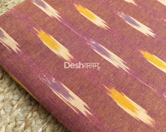 May include: Close-up of a fabric with a brown background and diagonal brushstroke patterns in yellow, purple, and white. The text "Deshवस्त्रम्" is printed in white, and "Fab121" is in the upper right corner.