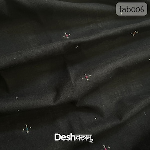 May include: Black fabric with a subtle texture and scattered, tiny floral-like designs in white, pink, and teal. The fabric has a slightly wrinkled appearance. The text "fab006" is in the upper right corner. The text "Deshवस्त्रम्" is in the lower left corner.