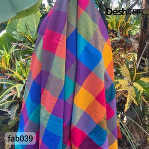 May include: A colourful fabric with a chequered design, featuring a mix of bright hues such as pink, purple, blue, orange, and yellow. The text "Desh" and "fab039" are visible on the fabric.