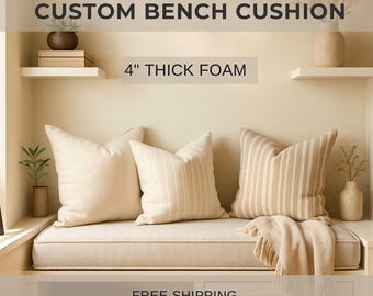 May include: A custom bench cushion with 4" thick foam, featuring three beige pillows and a matching throw. Two pillows have vertical stripes. The bench is set against a neutral wall with decorative shelves and vases.