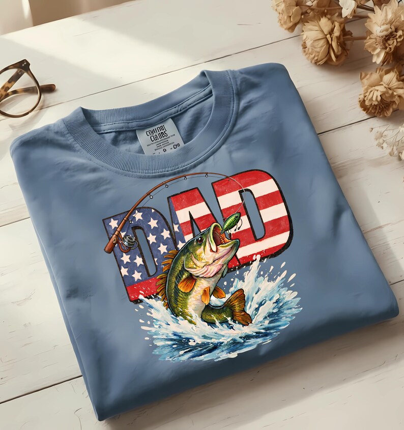 Father's Day and 4th of July fishing shirt design featuring a bold American flag bass fishing DAD graphic, shown as an instant digital download PNG for sublimation, DTF, and Cricut projects