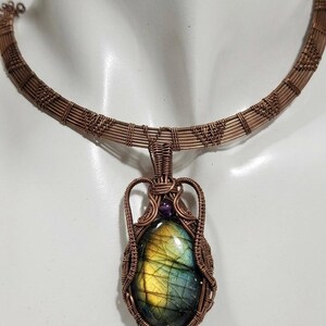 May include: A white ceramic mug with a black handle and the text "But First, Coffee" in a bold, black font. The mug is filled with a dark liquid, likely coffee, and rests on a light-coloured surface.