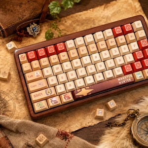 May include: A mechanical keyboard with a dark wood frame and cream-colored keycaps featuring red accents. The keys display custom Monster Hunter themed graphics and gothic-style lettering. The spacebar is labeled with the text Monster Hunter.