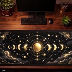 Könnte beinhalten: Schwarze Schreibtischunterlage mit einem goldenen Himmelsdesign, das Mondphasen, Sterne und Planeten zeigt. Die rechteckige Matte ist für die Verwendung mit einem Computer-Setup konzipiert.