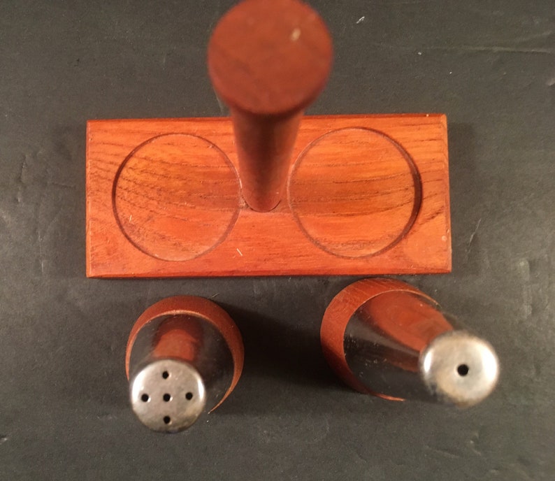 mid-century wood and metal salt and pepper shakers on a stand