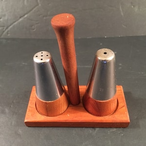 mid-century wood and metal salt and pepper shakers on a stand