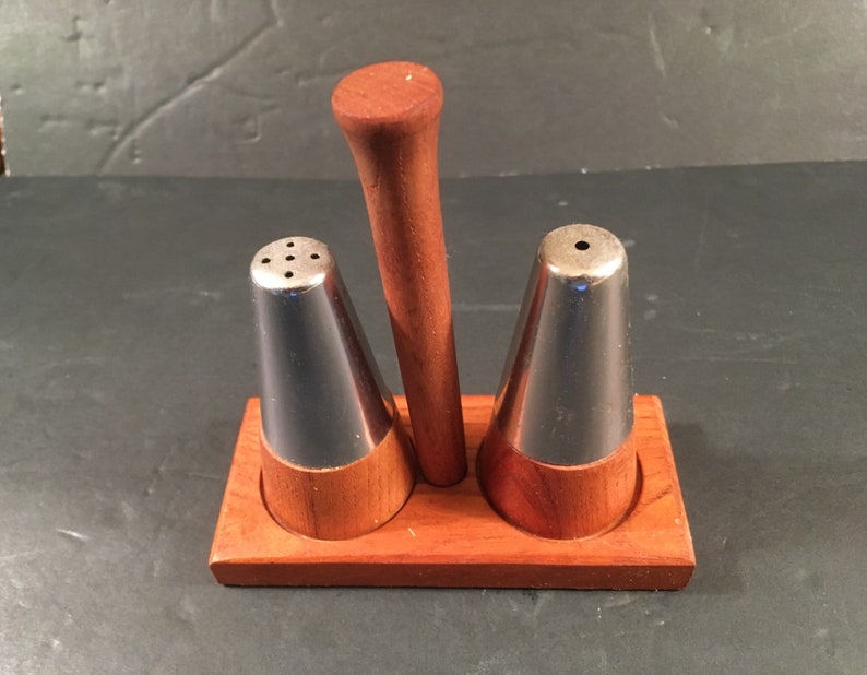 mid-century wood and metal salt and pepper shakers on a stand