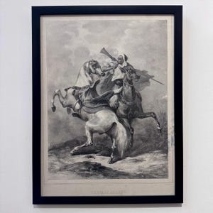 May include: Black and white framed print depicting a historical scene with a person on horseback blowing a horn, accompanied by another horse. The artwork is framed in a black frame and features the text "CHEVALIERS ARABES" at the bottom.
