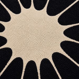 May include: A circular rug featuring a textured, tufted surface with a high-contrast design. The center is a solid cream-colored circle, surrounded by radiating, petal-like shapes in black that extend outward to the edge of the rug.