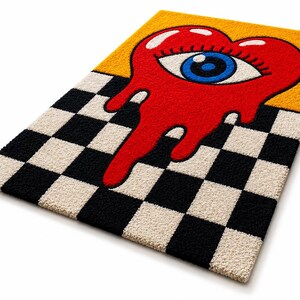 May include: A rectangular tufted rug featuring a black and white checkered pattern on the bottom half and a solid yellow background on the top half. A large red heart shape with a blue and white eye in the center appears to be melting downward.