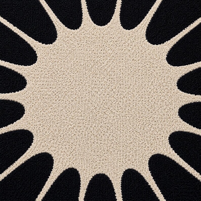 May include: A circular rug featuring a textured cream-colored center with radiating, petal-like extensions that reach outward. The background between these cream-colored extensions is a solid, deep black, creating a high-contrast sunburst pattern.