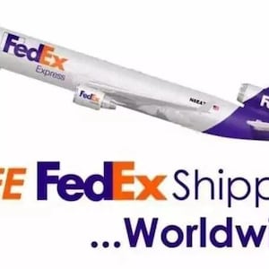 May include: A white cargo airplane with purple and orange FedEx Express branding on the fuselage and tail. The text FedEx Express is visible on the side of the plane, and the text FREE FedEx Shipping ...Worldwide! appears below the aircraft.