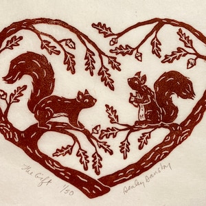 May include: A brown linocut print of two squirrels in a heart-shaped tree. The print is titled "The Gift" and numbered 1/50. The artist's signature, "Bealey Dansby", is in the lower right corner.