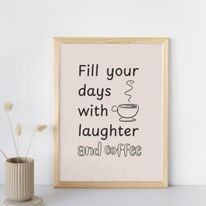 Puede incluir: Impresión enmarcada con las palabras negras "Fill your days with laughter and coffee". La impresión tiene un fondo rosa claro y una ilustración de taza de café. El marco es de madera clara.