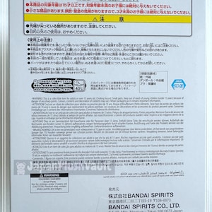May include: Warning label on a product box with Japanese text, English warnings about choking hazards, small parts, and age restrictions. The box is white with colorful text and graphics.
