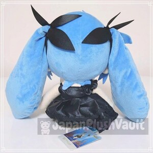 May include: A plush doll with long, light blue hair and black accents. The doll has a black dress and is holding a small card. The doll's hair is styled with black ribbons. The doll is a soft, cuddly toy.